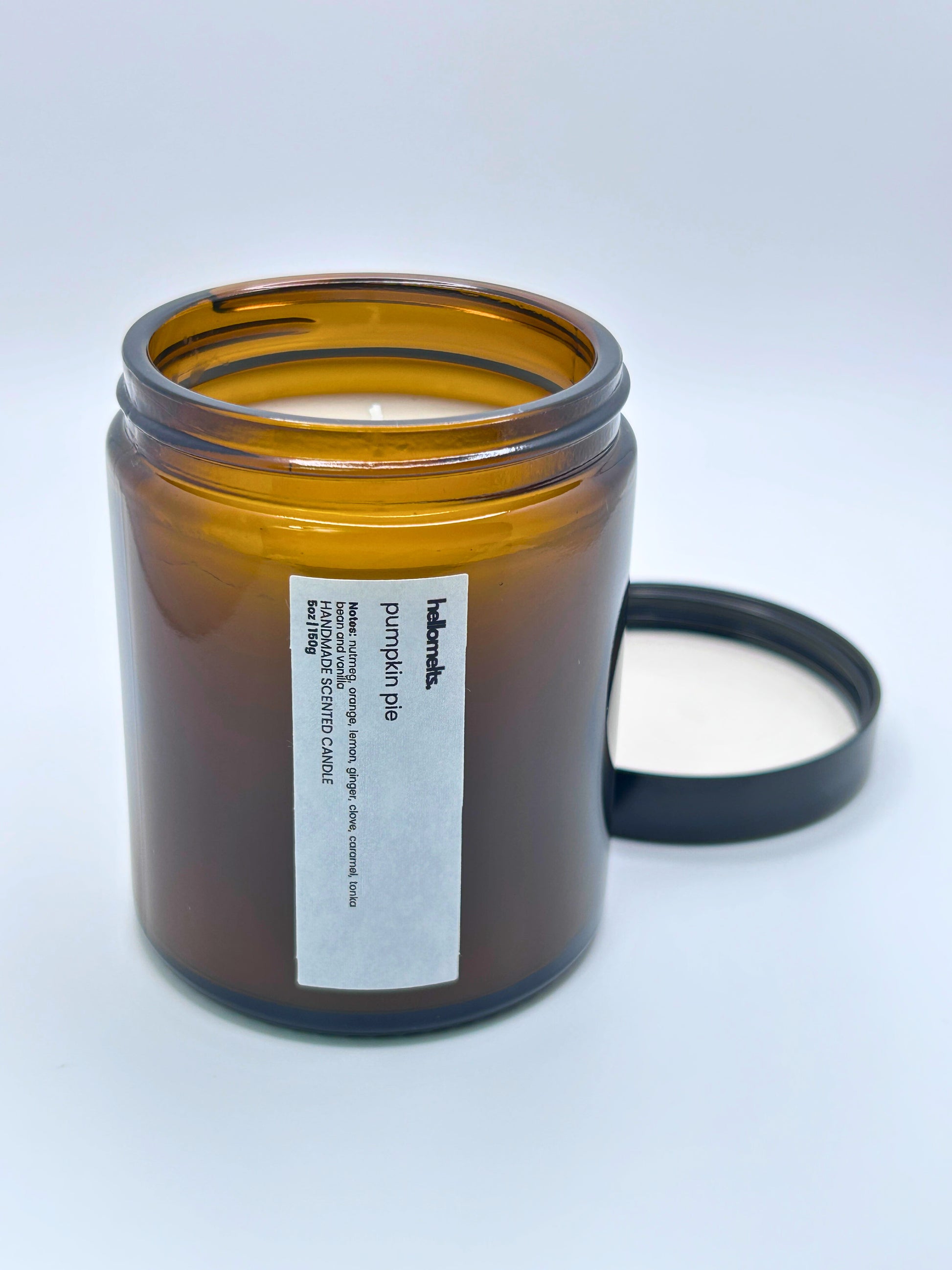 Angled view of Pumpkin Pie autumn candle by Hellomelts, showcasing the amber jar from the Autumn Collection