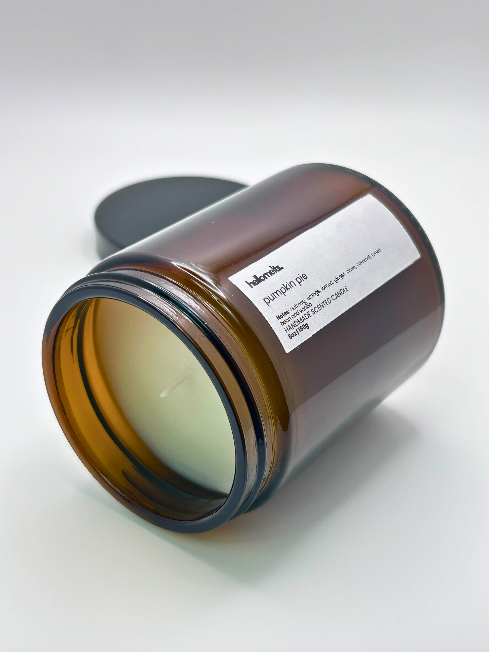 Pumpkin Pie autumn scented candle by Hellomelts lying on its side with the wick facing forward, part of the Autumn Collection