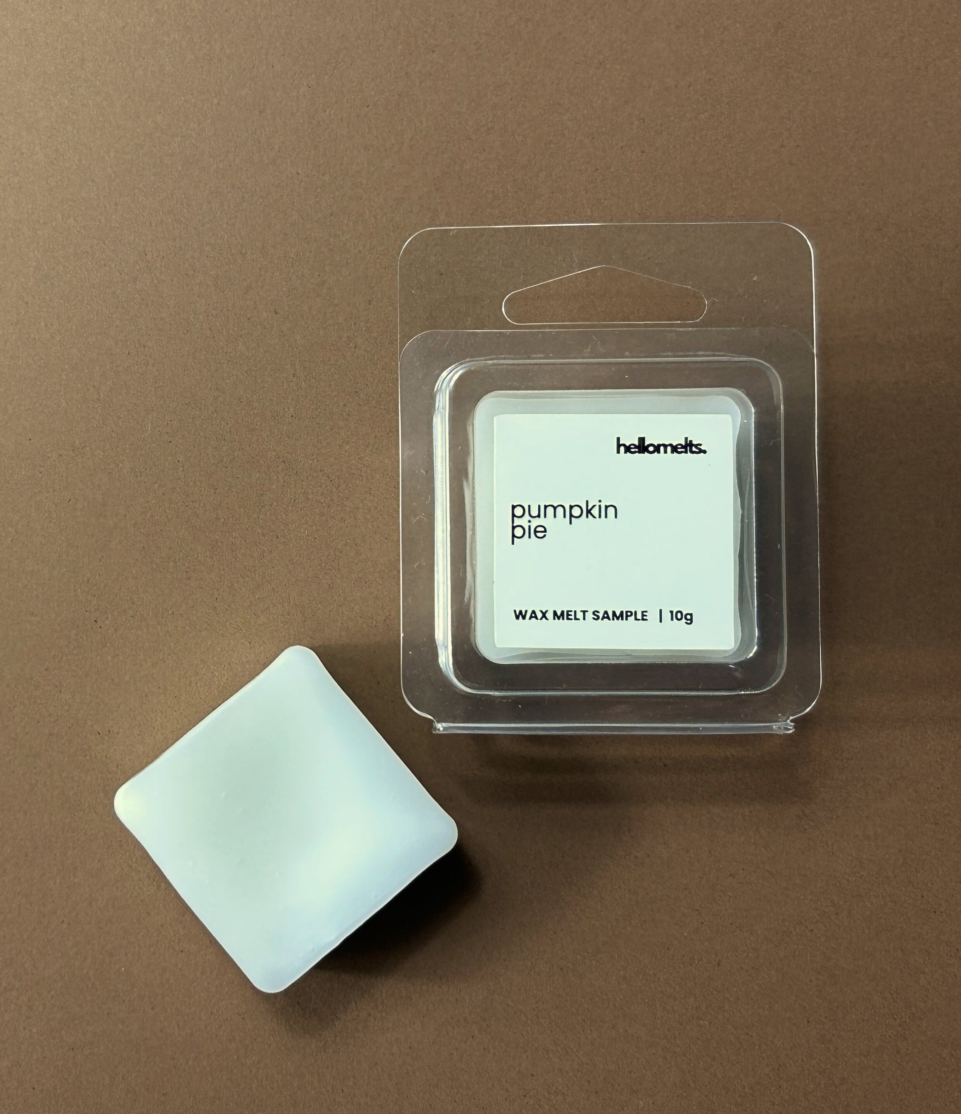 Hellomelts Pumpkin Pie free 10g wax melt sample in clamshell packaging with melt shown beside it, styled on a brown background as part of the Autumn Collection