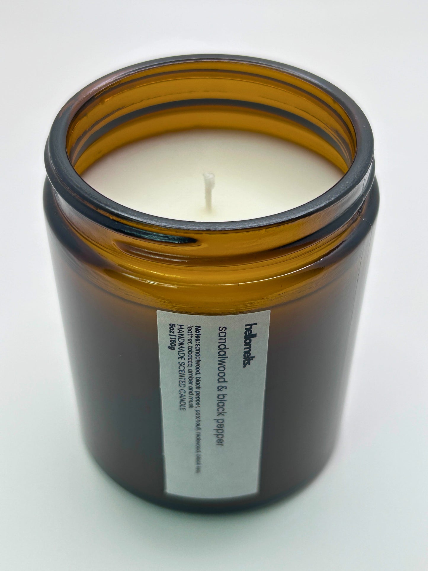 Angled top-down view of Sandalwood & Black Pepper autumn candle by Hellomelts, highlighting the wick and hand-poured wax, part of the Autumn Collection