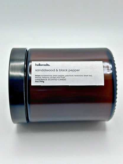 Close-up of Sandalwood & Black Pepper candle by Hellomelts lying down with the lid on, part of the autumn collection.