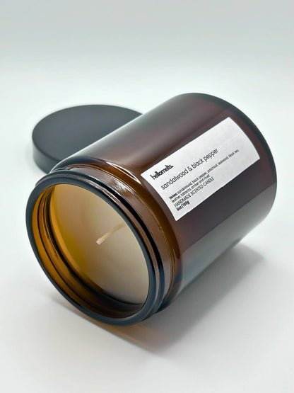 Sandalwood & Black Pepper candle by Hellomelts lying down with the wick facing forward, part of the autumn collection.