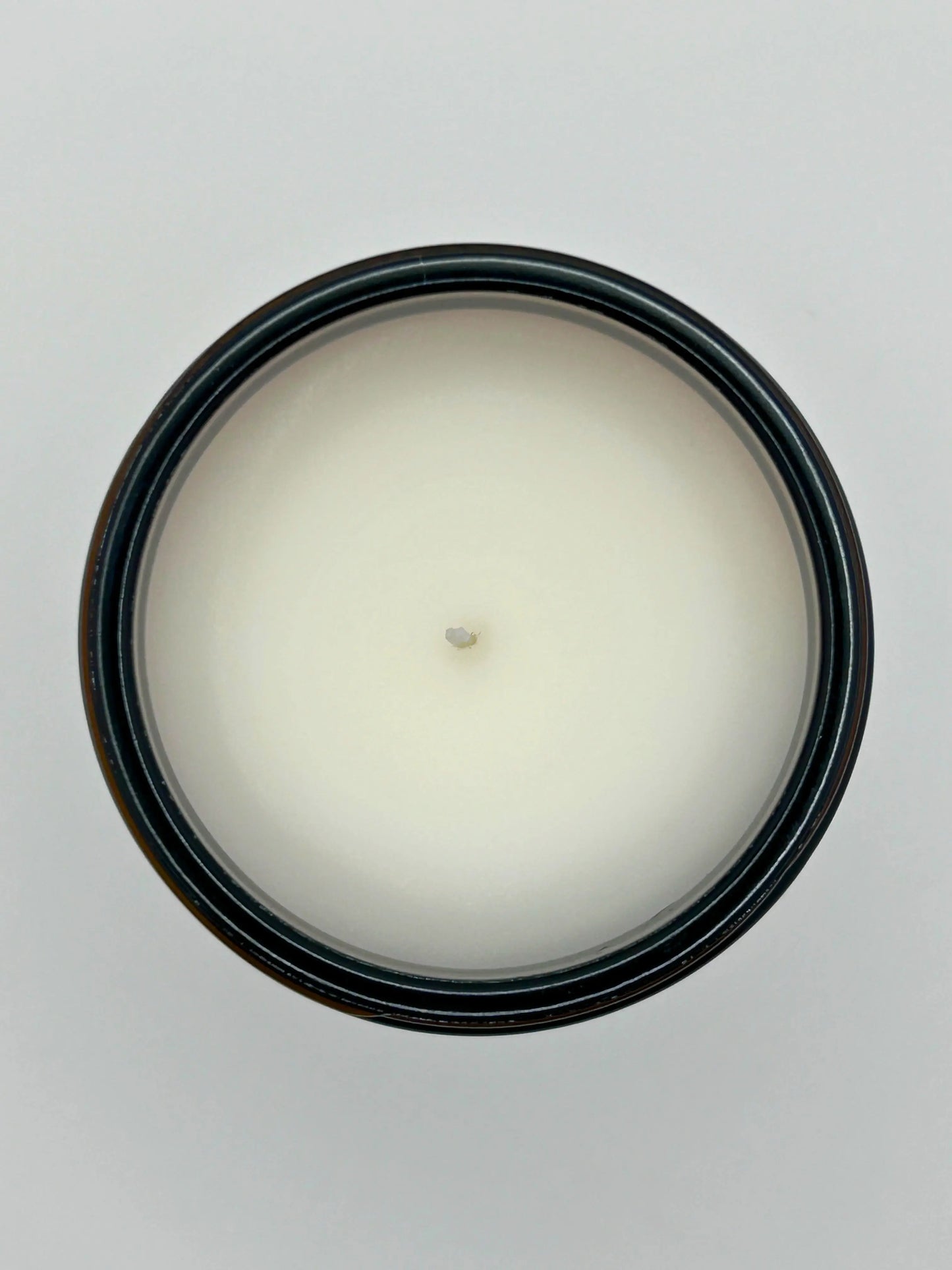 Top view of Sandalwood & Black Pepper candle from Hellomelts, showing the hand-poured wax in an amber jar from the autumn collection.