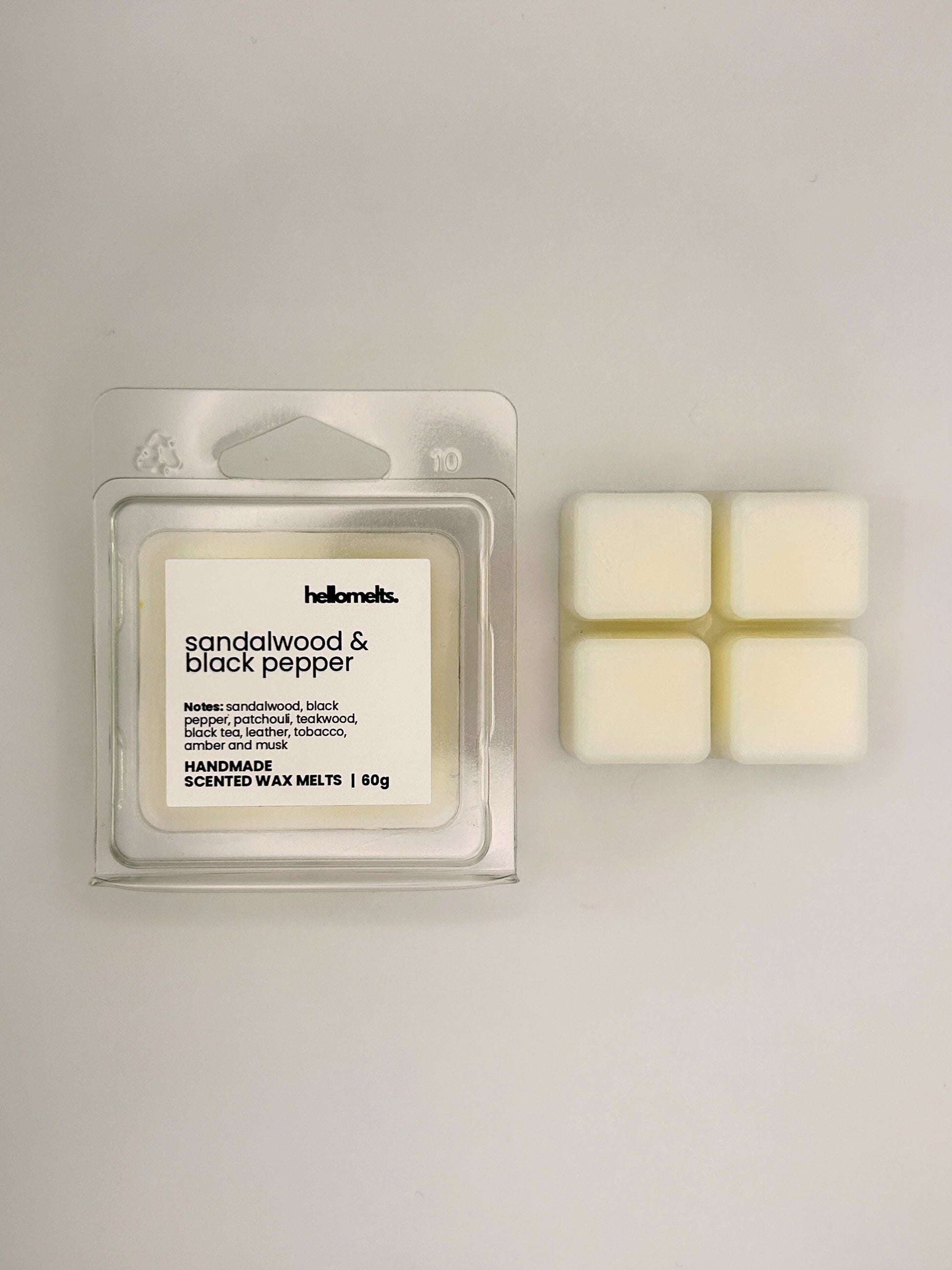 Sandalwood & Black Pepper 60g wax melt bar displayed beside its clear clamshell packaging from the Hellomelts Autumn Collection