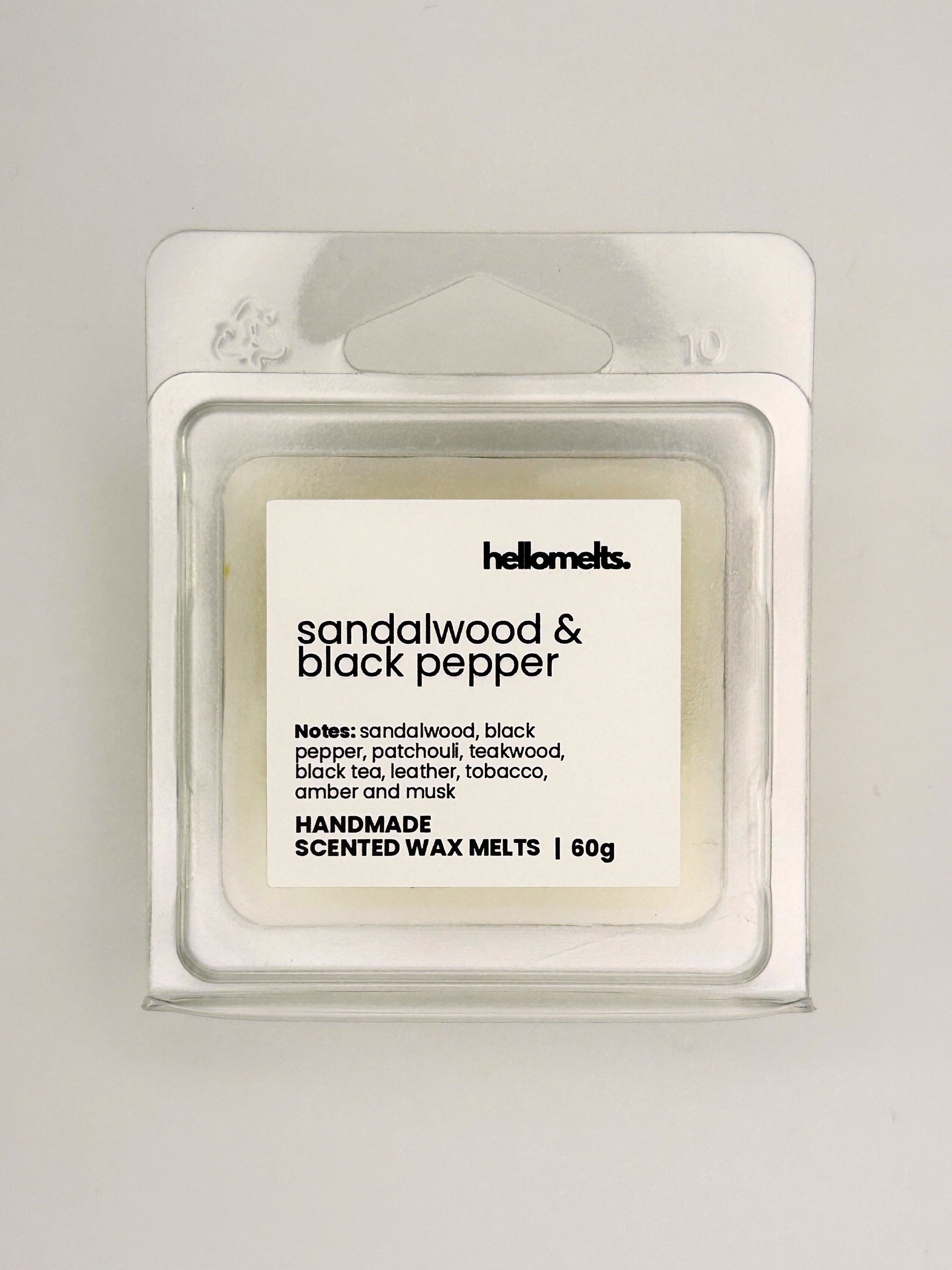 Close up of Sandalwood & Black Pepper 60g wax melt label on clear clamshell packaging from the Hellomelts Autumn Collection