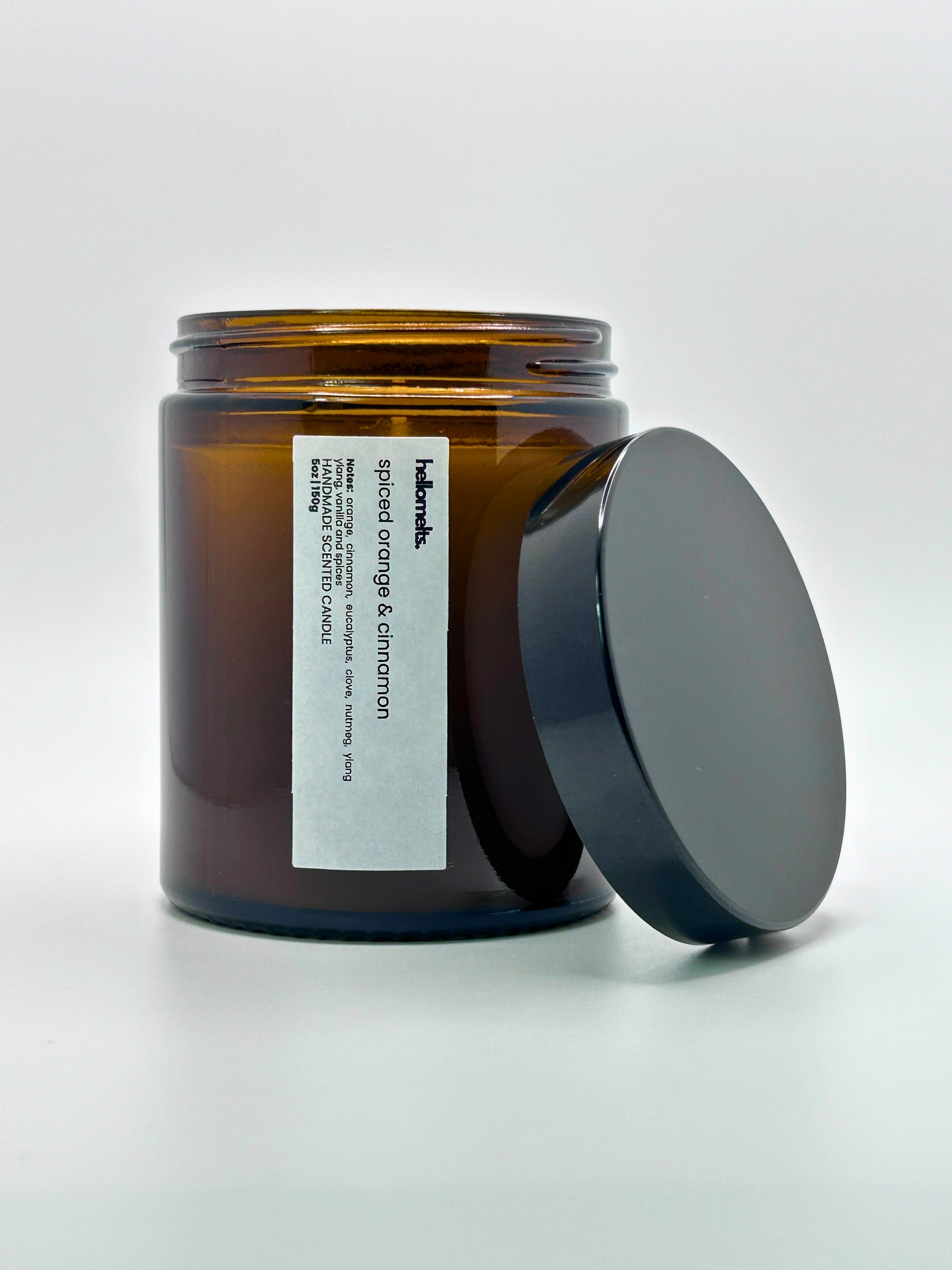 Front view of Spiced Orange & Cinnamon autumn scented candle by Hellomelts with the lid placed beside it, part of the Autumn Collection