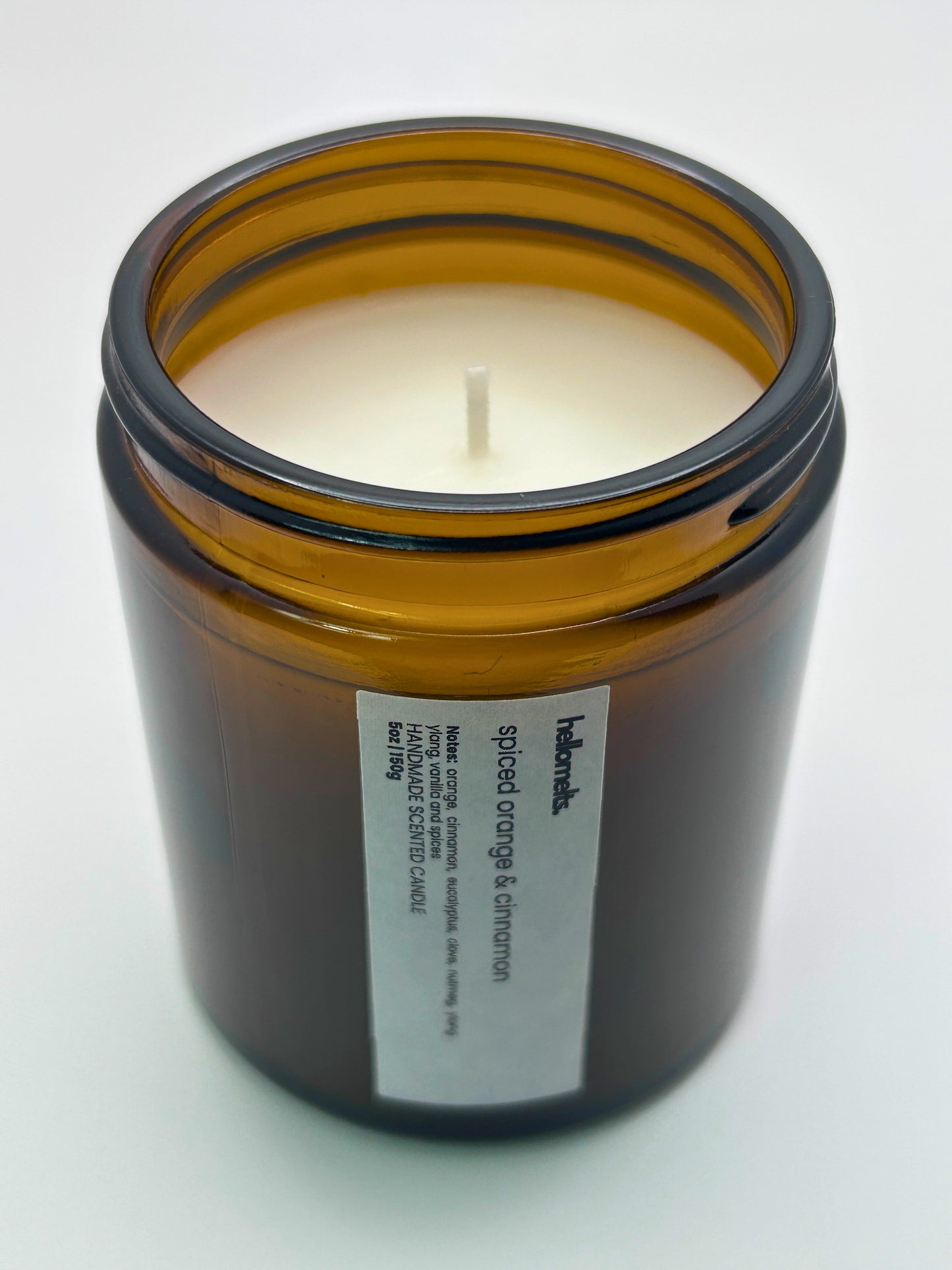 Angled top-down view of Spiced Orange & Cinnamon autumn candle by Hellomelts, highlighting the wick and hand-poured wax, part of the Autumn Collection