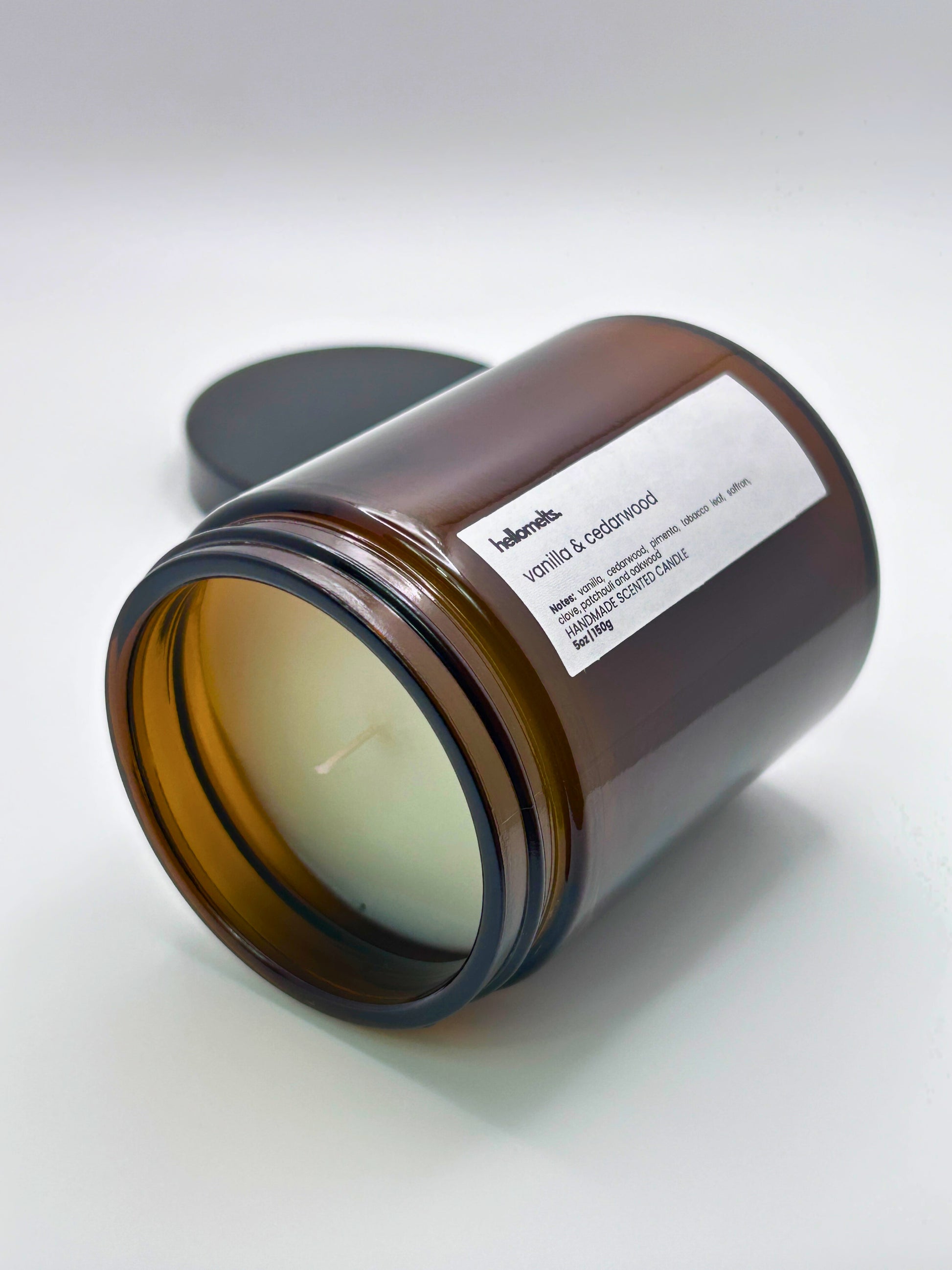 Vanilla & Cedarwood autumn scented candle by Hellomelts lying on its side with the wick facing forward, part of the Autumn Collection