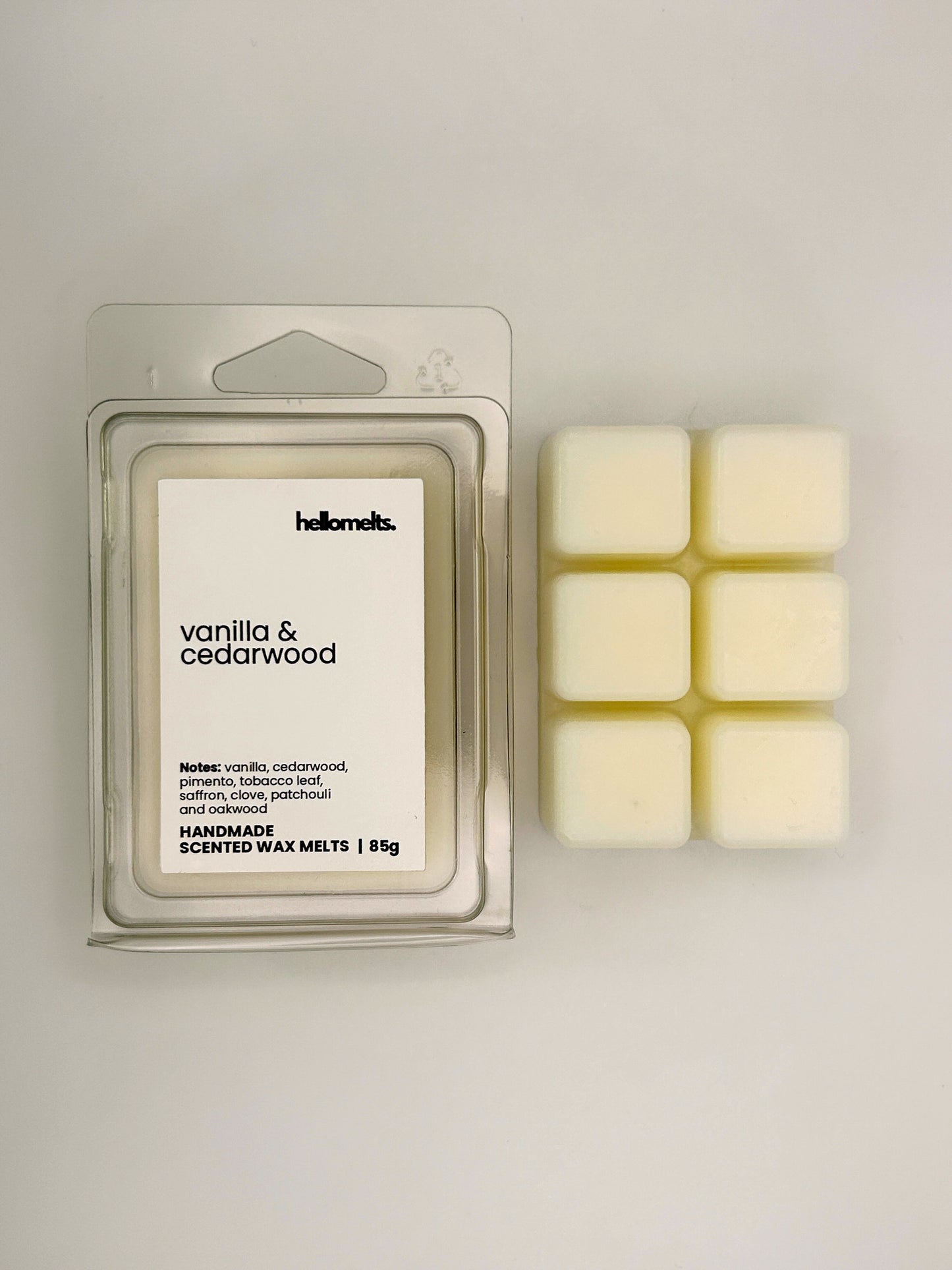 Vanilla & Cedarwood 85g wax melt bar displayed beside its clear clamshell packaging from the Hellomelts Autumn Collection