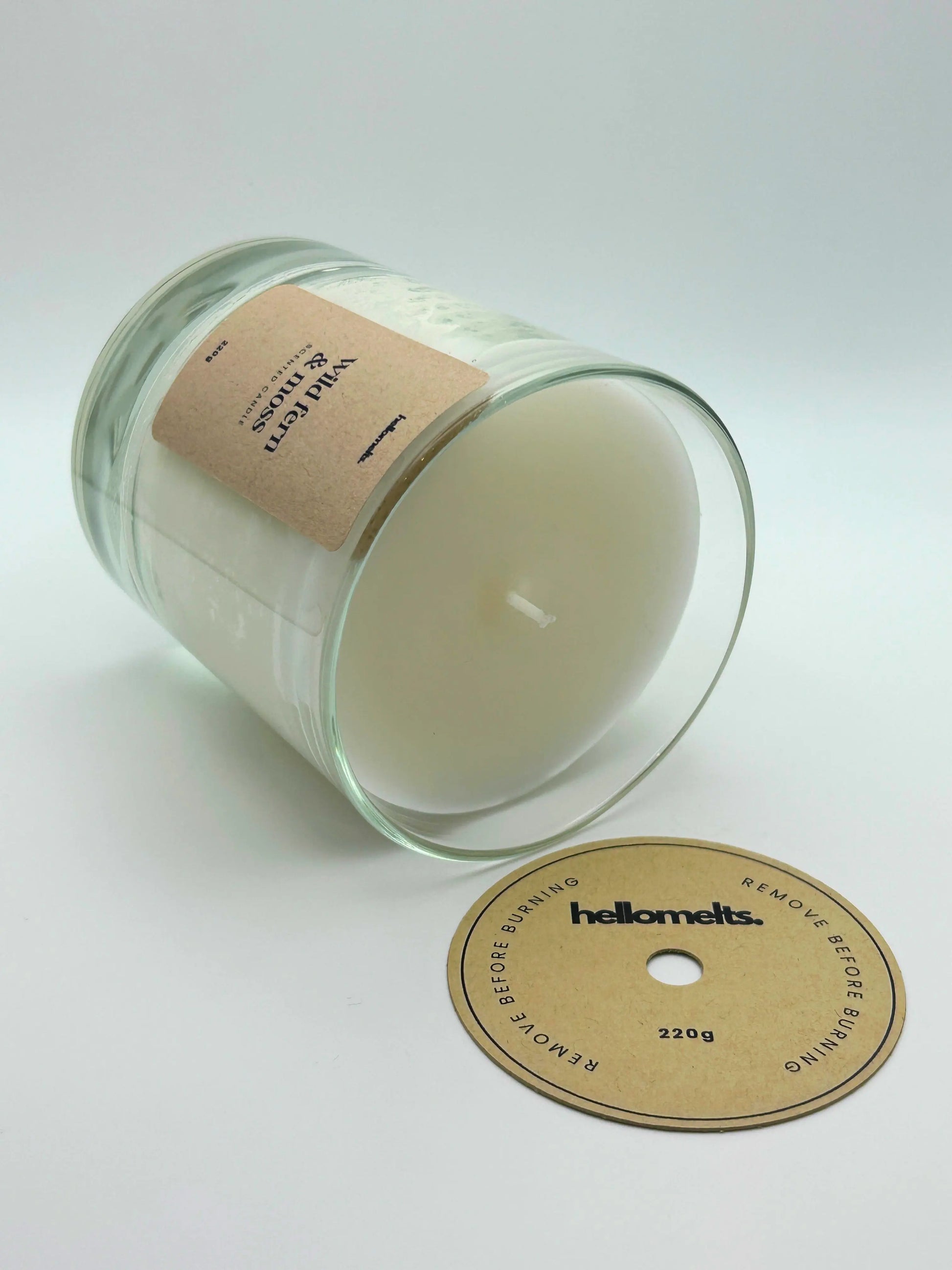 Wild Fern & Moss candle lying flat with the wick cover removed and placed beside it, showing the smooth wax finish by Hellomelts.