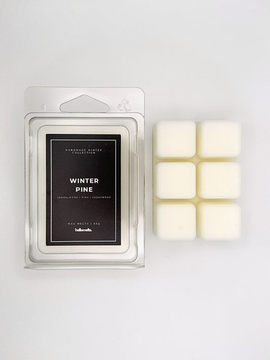 Winter Pine 85g wax melt clamshell placed beside six wax cubes from the Hellomelts Winter Collection