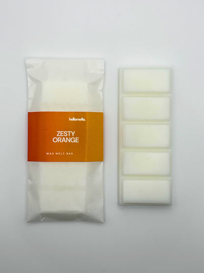 Zesty Orange 50g wax melt bar by Hellomelts, shown unwrapped beside the five-bar segmented wax melt.