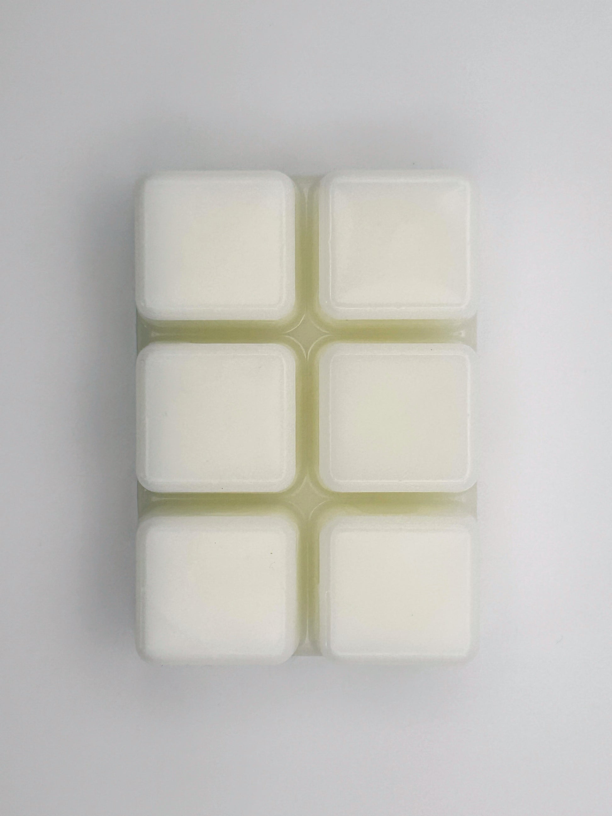 Flatlay of Zesty Orange wax melt bar in 85g size, removed from packaging to show 6 cubed wax melt bar