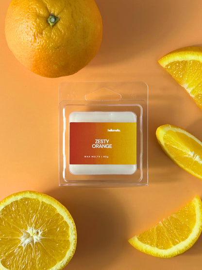 Zesty Orange wax melt bar in clear clamshell packaging, styled with fresh orange slices on a light background, Hellomelts Summer Collection